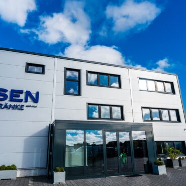 Ein zweistöckiges Gebäude mit einem Schild mit der Aufschrift „Ipsen“ auf der Vorderansicht.